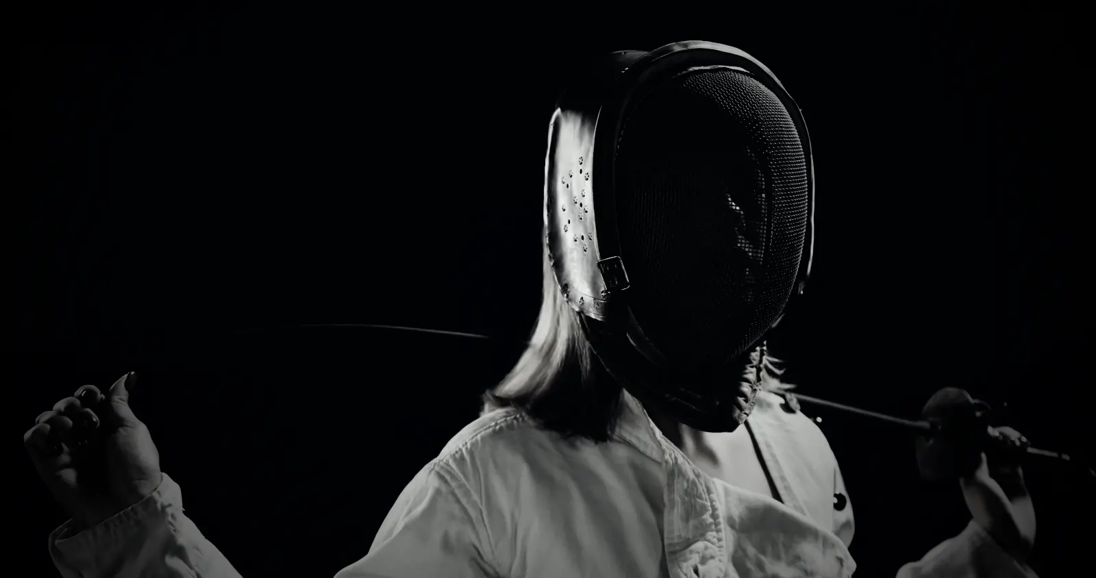 A fencer holding her blade behind her neck