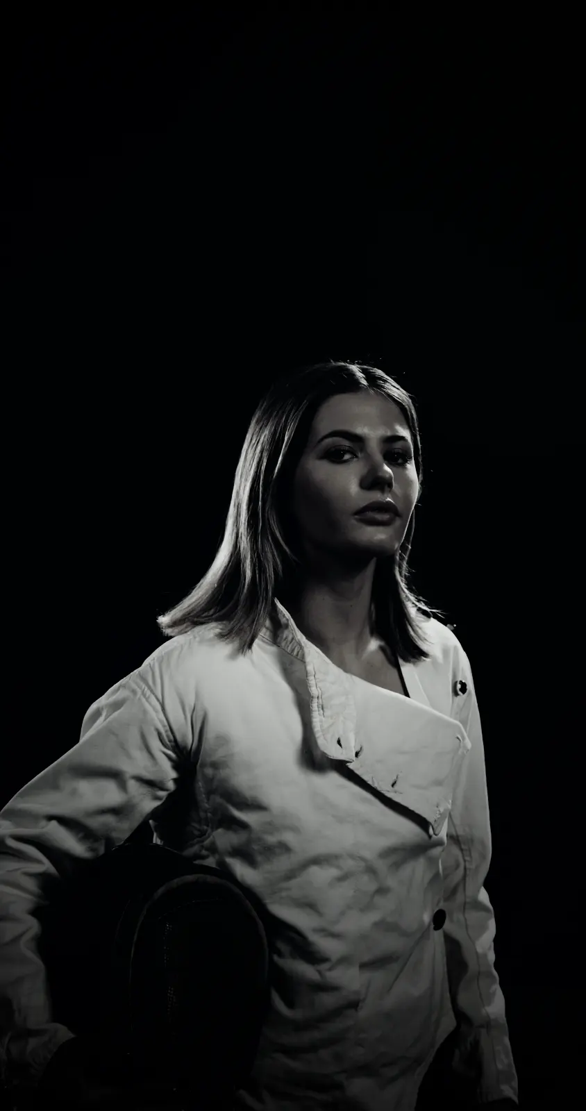 A fencer with her mask under her arm